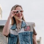 woman in blue denim button up vest wearing brown sunglasses