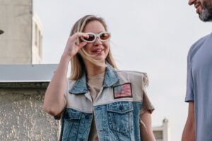 woman in blue denim button up vest wearing brown sunglasses