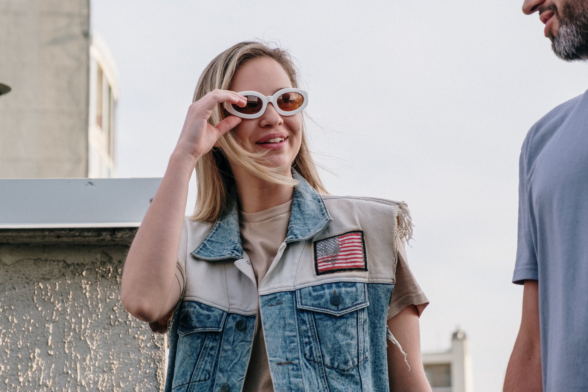 woman in blue denim button up vest wearing brown sunglasses